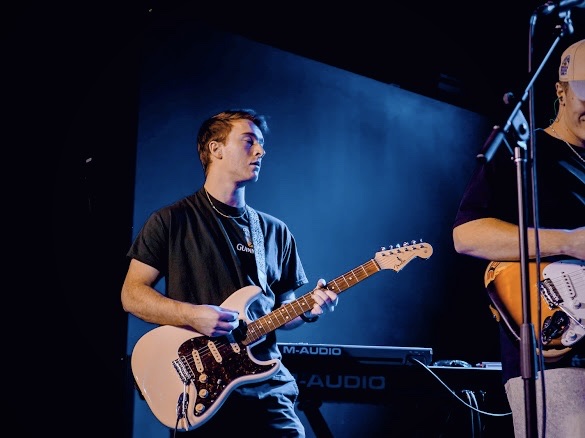 Kobey playing electric guitar on stage